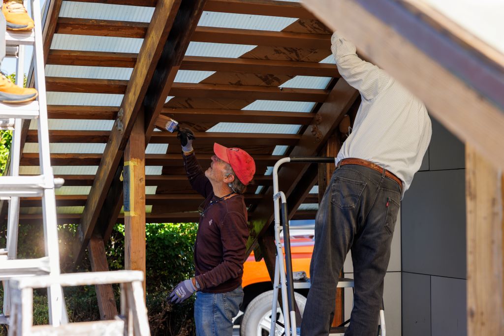 Volunteers repainting a bus stop shelter roof